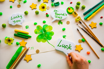 Drawing a green lucky clover st. Patrick. Top view of the hands.  Saint Patrick's Day concept.