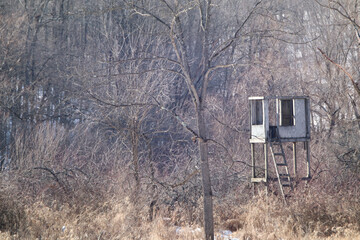 Hunting deer blind or deer stand in rural Ohio countryside after hunting season with trees in the winter background - Powered by Adobe