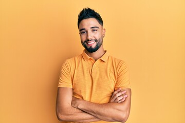 Young man with beard wearing casual clothes happy face smiling with crossed arms looking at the camera. positive person.