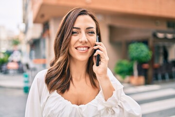 Young hispanic woman smiling happy talking on the smartphone at the city.