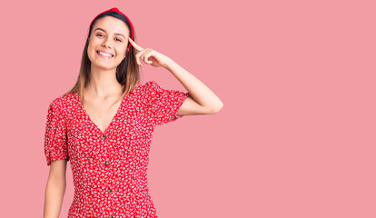 Young beautiful girl wearing dress and diadem smiling pointing to head with one finger, great idea or thought, good memory