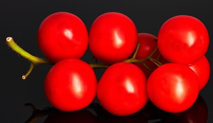 red tomatoes lie on a black background.......