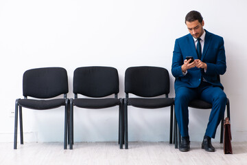 Young businessman waiting for an interview at hall