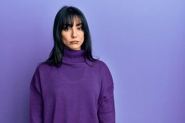 Fototapeta premium Young brunette woman with bangs wearing turtleneck sweater depressed and worry for distress, crying angry and afraid. sad expression.