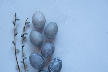 Easter gray marble eggs and branches of  pussy willow on a gray concrete background.Easter symbol. Spring religious holiday.Easter background in gray tones in minimalist style