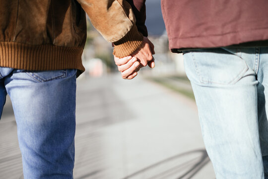 Hands of two boys interlaced while walking
