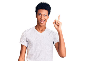 Young african american man wearing casual white t shirt pointing finger up with successful idea. exited and happy. number one.