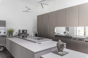 Grey modern kitchen with island and silver accessories