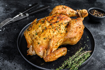 Homemade whole baked chicken rotisserie with thyme.  Black background. Top view