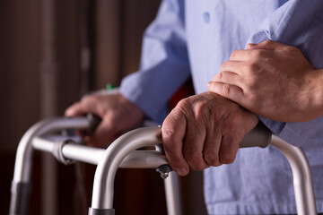 Closeup of senior man's hands holding walker at nursing home