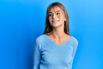 Obraz premium Teenager caucasian girl wearing casual clothes and glasses looking to side, relax profile pose with natural face and confident smile.