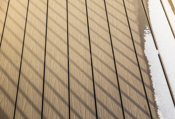 Beautiful background texture in form of light brown planks on balcony in winter day.