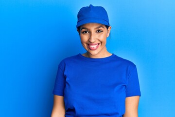Beautiful brunette woman wearing delivery uniform looking positive and happy standing and smiling with a confident smile showing teeth