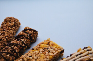Four granola bars are lined with a fan on the lower left edge on a blue background with a copy space. High quality photo