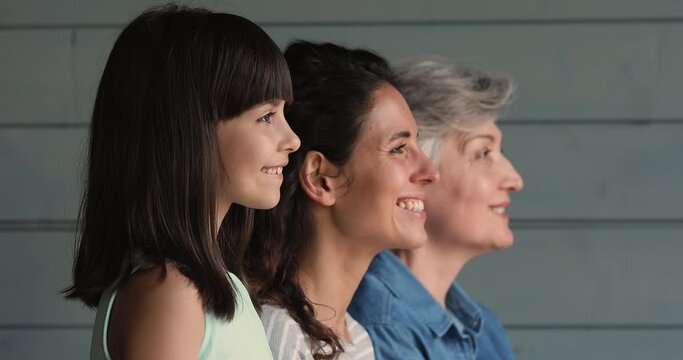 Profile view 3 generation of women on studio, little girl smile look at camera pose with young mom pensioner elderly grandma. Heredity, traits from parents to offspring, three gen family bond concept