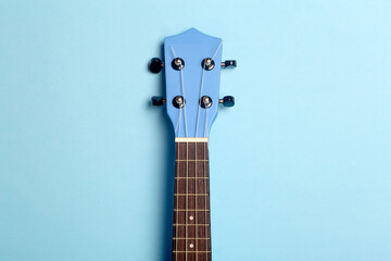 Guitar ukulele on a blue background. Music playing guitar concept