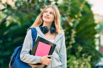 Obraz premium Beautiful caucasian student teenager smiling happy using headphones at the park.