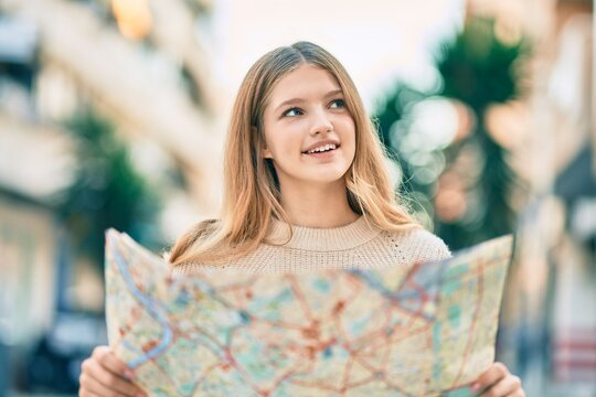 Beautiful caucasian tourist teenager smiling happy holding map at the city.