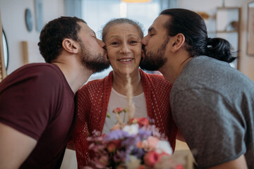 Sons congratulate mom on the holiday. Men visiting their beloved mother on a holiday