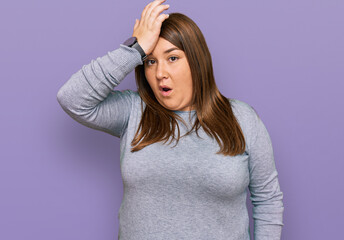 Beautiful brunette plus size woman wearing casual clothes surprised with hand on head for mistake, remember error. forgot, bad memory concept.