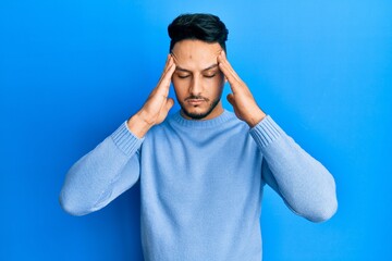 Young arab man wearing casual clothes with hand on head, headache because stress. suffering migraine.