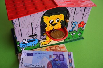 old hungarian retro doghouse money box toy with toy euro coins and banknotes