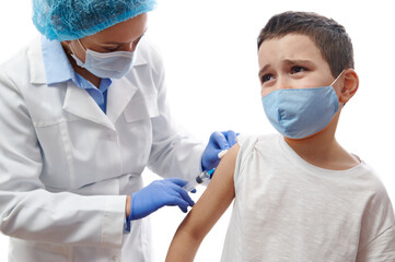 Fototapeta premium Doctor making injection on boy's hand. Vaccination on white background. Boy afraid of vaccination and injection.