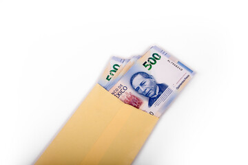 Sobre amarillo con billetes nuevos de 500 pesos.
Yellow envelope with new 500 peso bills.