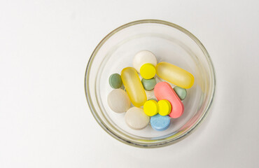 Colorful pills vitamins and antibiotics lie beautifully on a white background