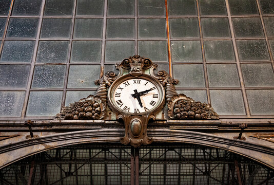 Old clock hanging on ancient market wall. - Powered by Adobe
