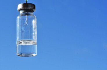 syringe with a needle in a vial of medicine
  on the background of the blue sky 