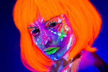 Portrait of woman in with neon makeup. Fluorescent paint in ultraviolet light