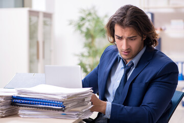 Young male employee unhappy with excessive work