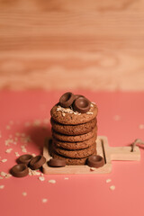oatmeal cookies on a pink background, sprinkled with oatmeal and chocolate chips. a sweet snack, beautiful food photo, pastry, bakery