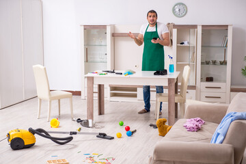 Young male contractor cleaning the flat after kids' party