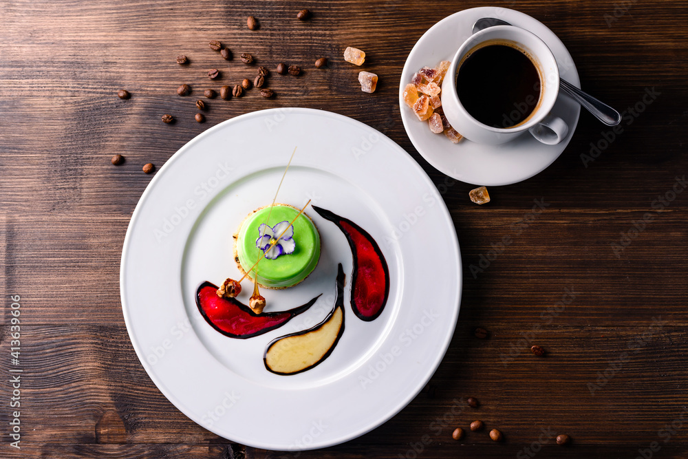 Poster Decorative dessert food. Beautiful green cake decorated served on round plate in Italian restaurant. Delicious desserts