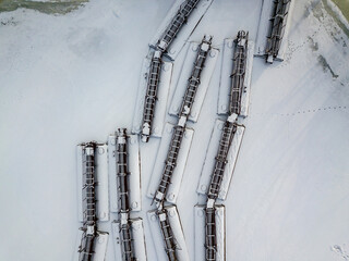 Metal gangways in a frozen industrial port. Aerial drone view. Winter snowy day.