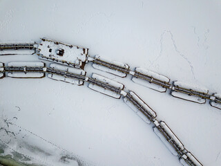Metal gangways in a frozen industrial port. Aerial drone view. Winter snowy day.
