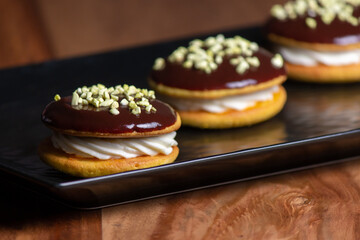 Bouche. Homemade stuffed desserts with pistachio crunches on top.