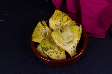 Artichoke Hearts in brown bowl red napkin, landscape, copyspace.