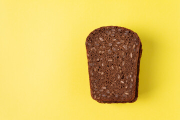 Bread with sunflower seeds on a yellow background. Horizontal orientation. View from above.