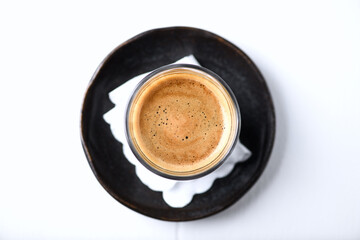 Coffee in glass cup on bright wooden background. Top view. 