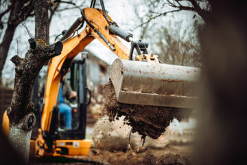 Worker using excavator and bulldozer for landscaping works - obrazy, fototapety, plakaty