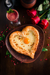 Valentines Day food. Heart shaped pizza, pie with cheese and egg in the shape of a heart and Red roses on the table