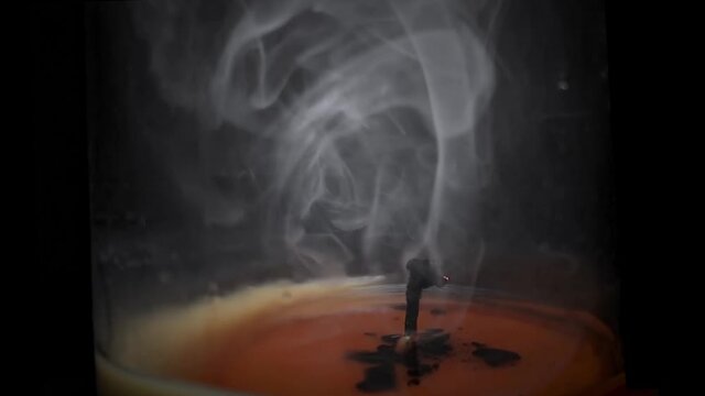 Close-Up Slow Motion Footage of a Snuffed Candle Wick with Smoke Swirling in the Jar