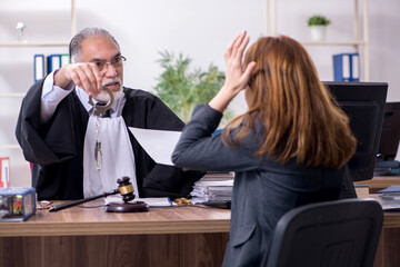 Old male judge and female client in the office