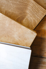Notebooks with a wooden cover lie on the table