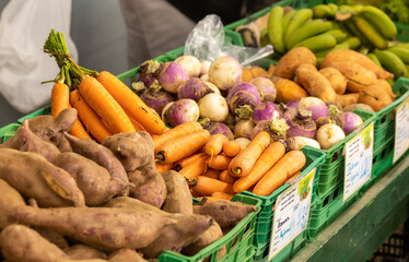 Carrots and potatoes on display at farmers market, fresh and healthy.