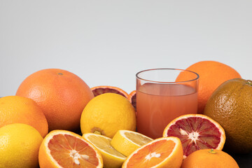 Sliced lemon and grapefruit with freshly squeezed grapefruit juice on white with free text space