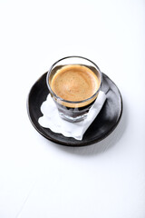 Coffee in glass cup on bright wooden background. Copy space. 